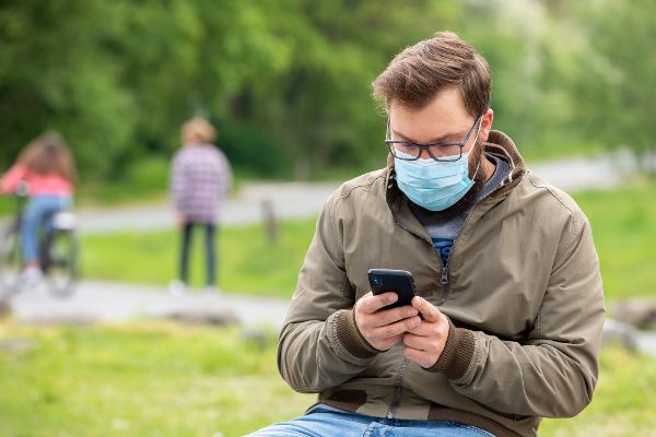 Personnes avec des masques utilisant des applications pour téléphones mobiles