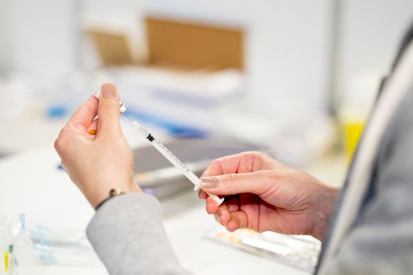 Eine Spritze mit Covid19-Impfstoff wird aufgezogen