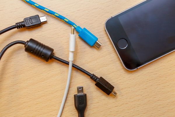 Verschiedene Ladekabel und ein Smartphone