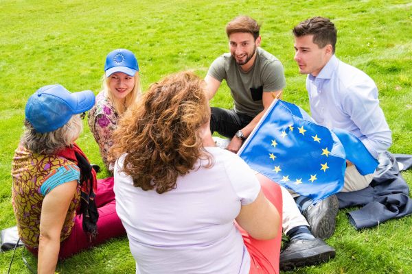 Freunde mit der Flagge der Europäischen Union in einem Park