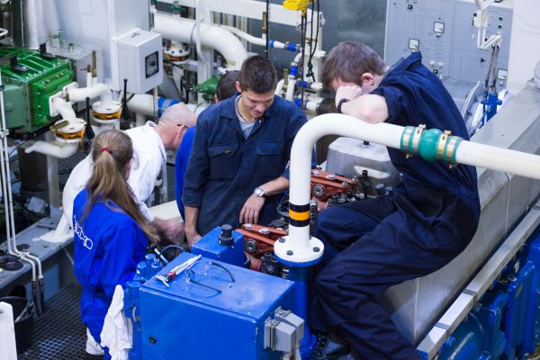 Auszubildende trainieren mit einer Maschine