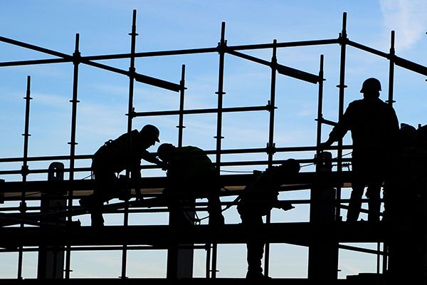 Bauarbeiter im Gegenlicht auf einem Gerüst