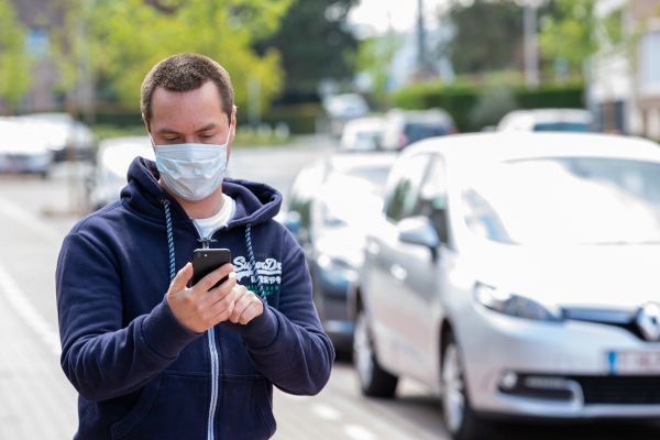 Mann mit Gesichtsmaske und Smartphone