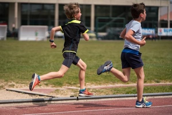 2 junge Buben laufen am Sportplatz. Foto: European Union / Francois Durand 2021