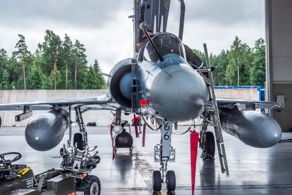 Ein stillstehender Jet und daneben stehend ein Pilot