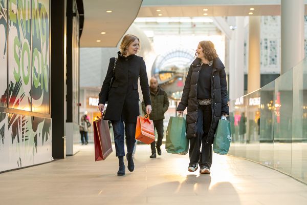 Foto: Menschen gehen mit Einkaufstaschen durch ein Einkaufszentrum