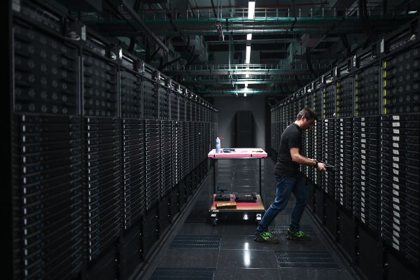 Ein Mann arbeitet an einem Serverschrank des Leonardo Supercomputers