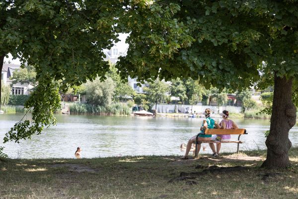Personen auf Parkbank an der alten Donau