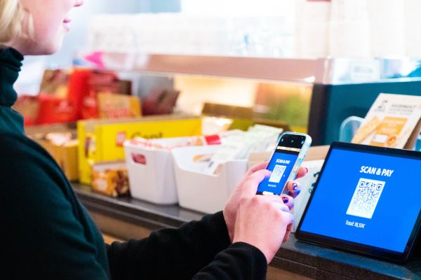 Das Foto zeigt eine Person beim kontaktlosen Zahlen