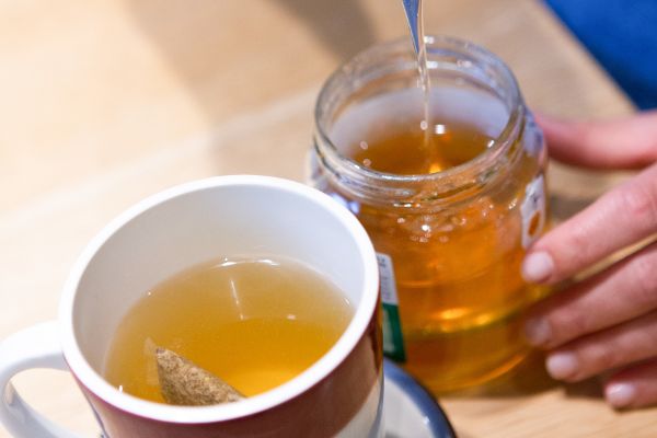 Tasse Tee mit Honig gesüßt