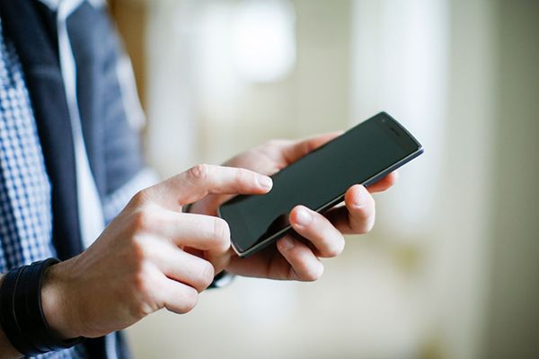 Symbolbild für Benchmark 2020 - Mann bedient Smartphone