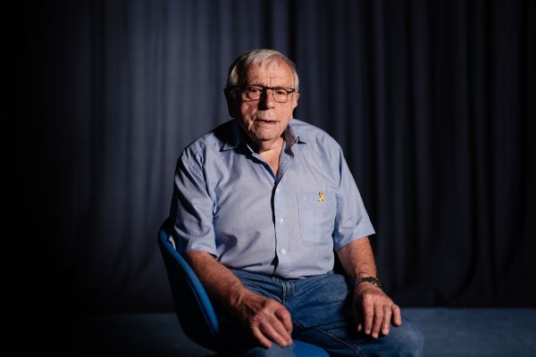 Heinrich Ehlers sitzt in einem blauen Hemd auf einem Stuhl.