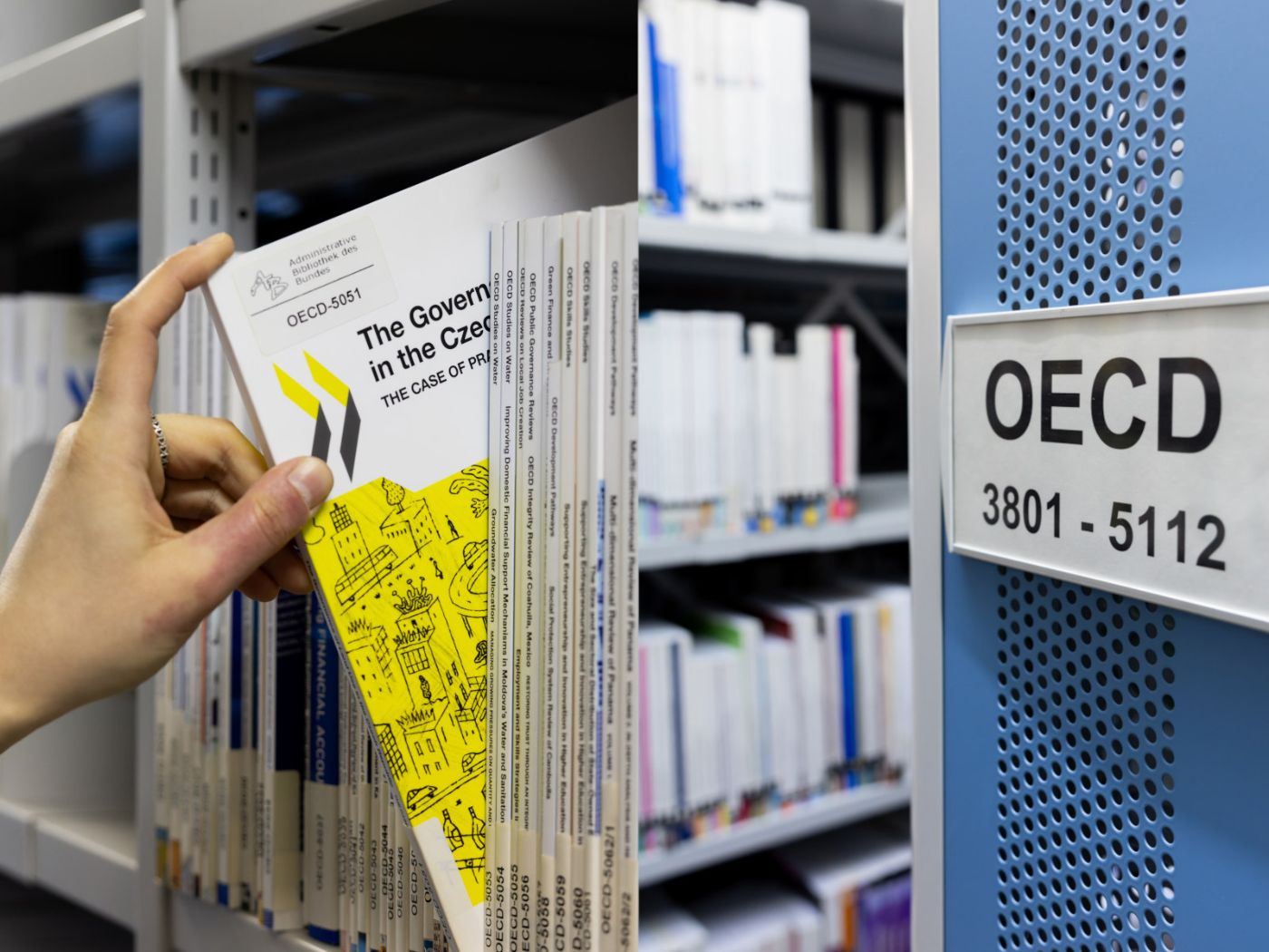 Left: An individual retrieves a book from the shelf; right: filing system in the magazine. Shelf labelling for the OECD inventory