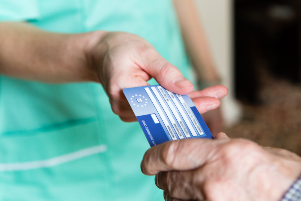 Ein Patient überreicht einem medizinischen Personal seine Europäische Krankenversicherungskarte