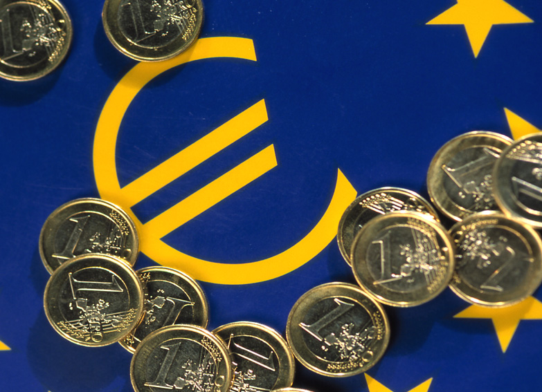 1-Euromünzen vor der Europäischen Fahne