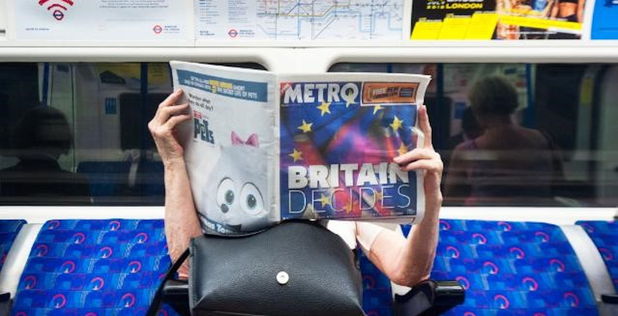 Frau liest in der U-Bahn eine Zeitung