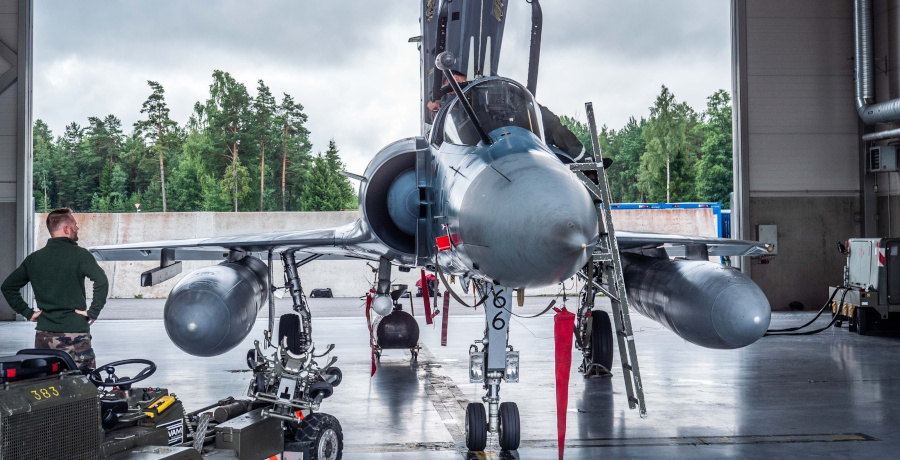 Ein stillstehender Jet und daneben stehend ein Pilot