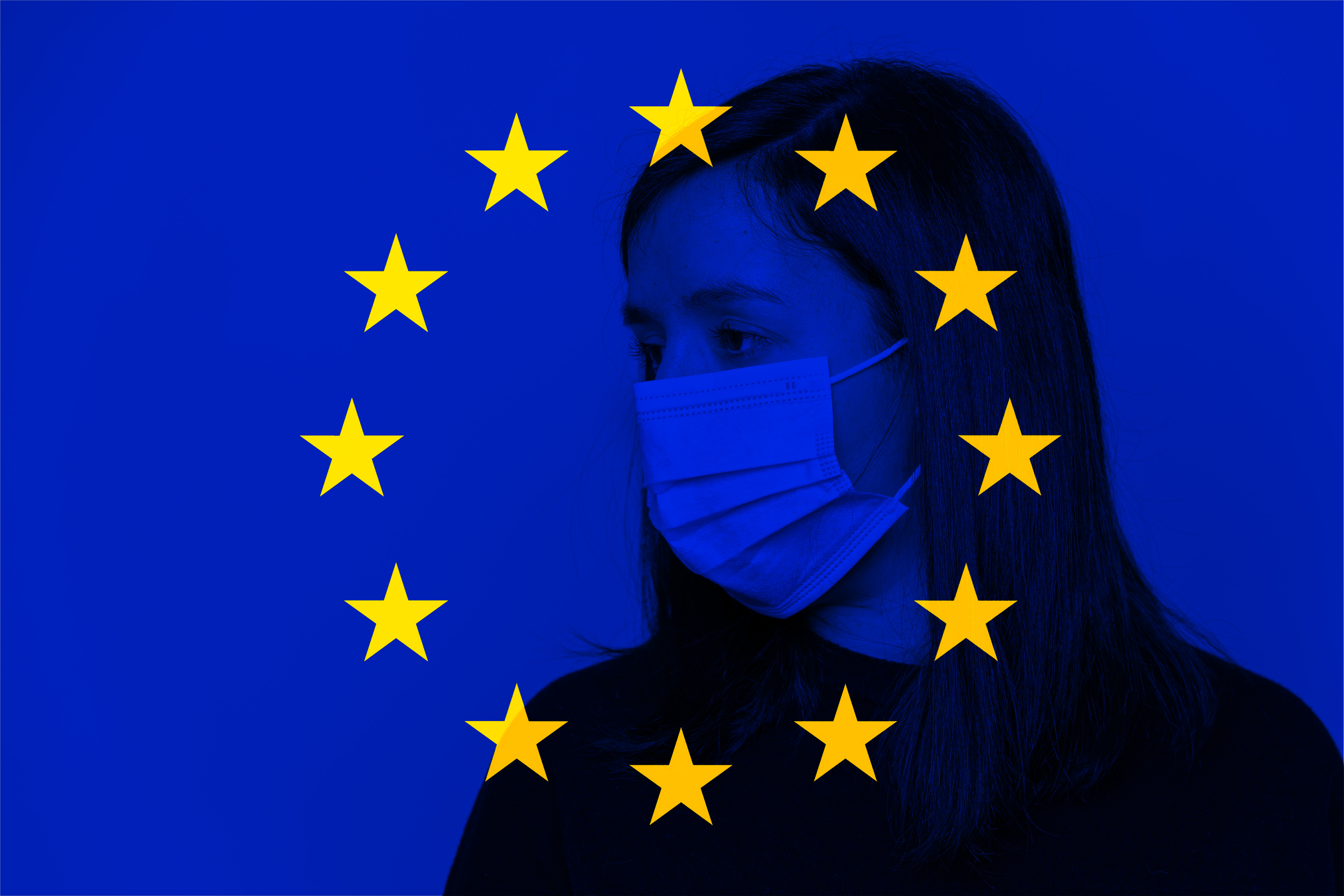 Foto einer Frau mit Mund-Nasen-Schutz hinter transparentem EU-Logo