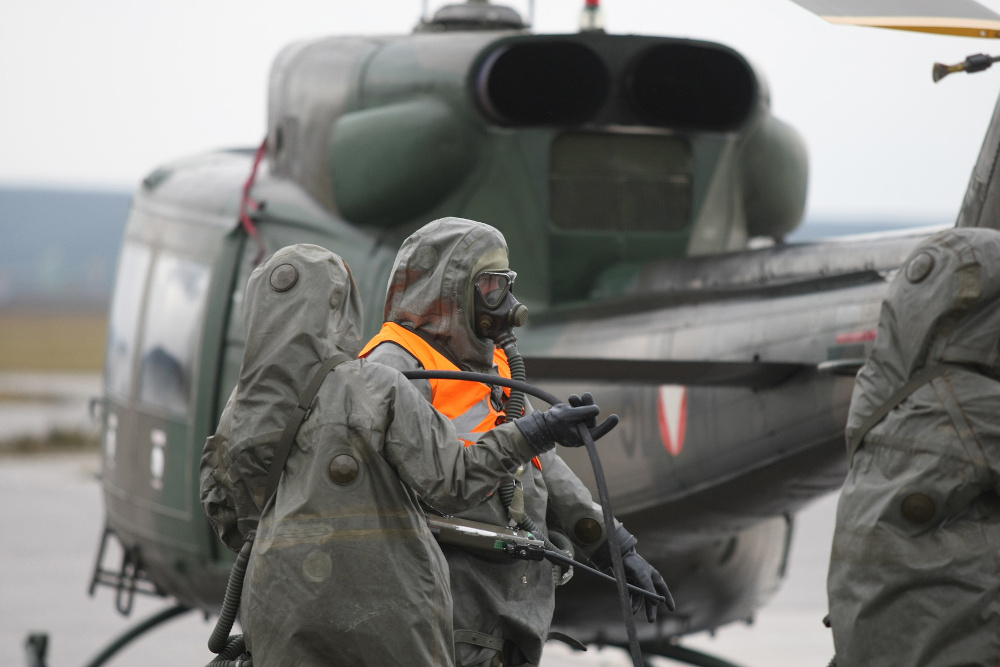 ABC-Soldaten beim dekontaminieren eines Helikopters