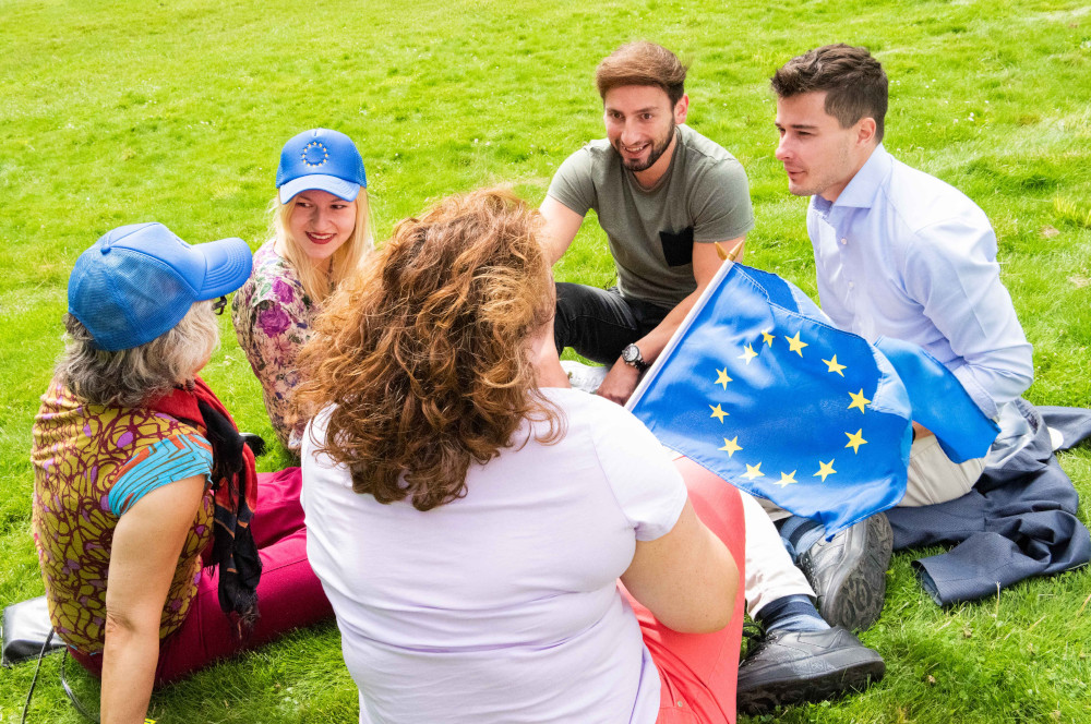 Freunde mit der Flagge der Europäischen Union in einem Park