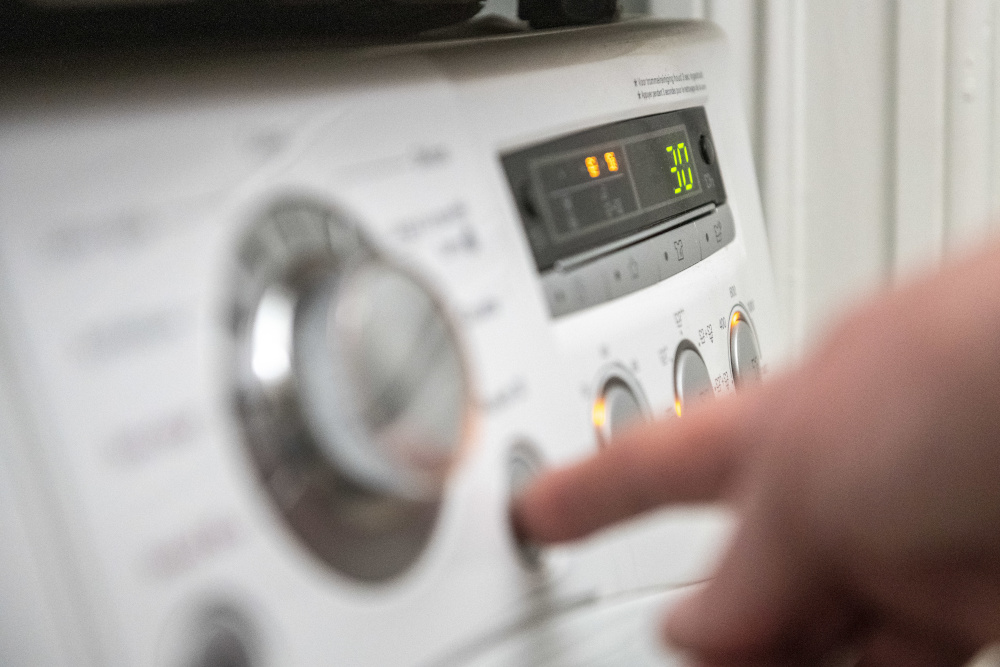 Eine Person betätigt eine Waschmaschine