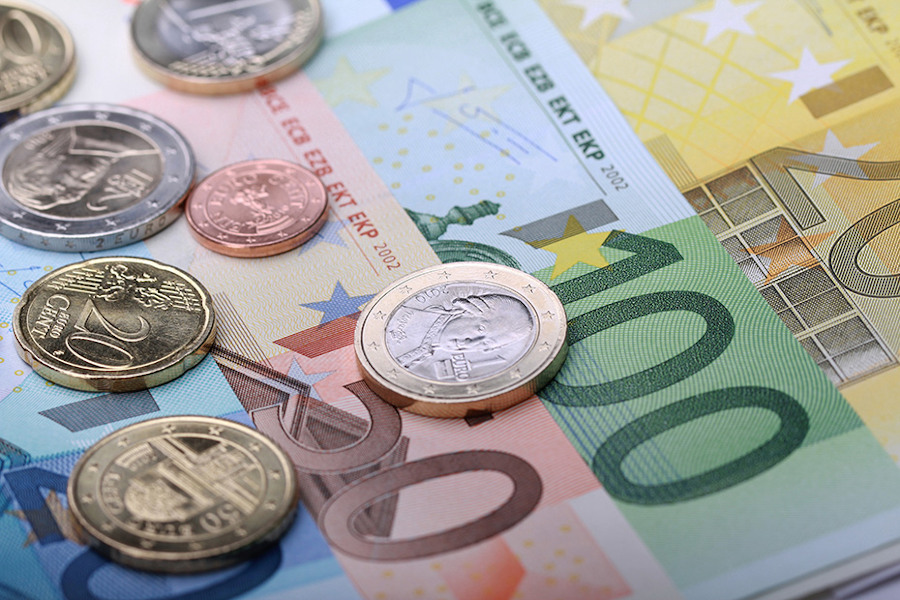 Geldmünzen (Euro) liegen auf Geldscheinen (Euro) drauf